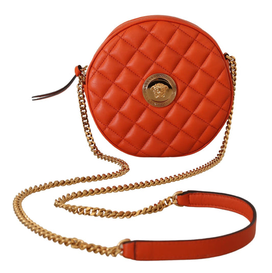 Orange quilted handbag with gold chain strap on a white background