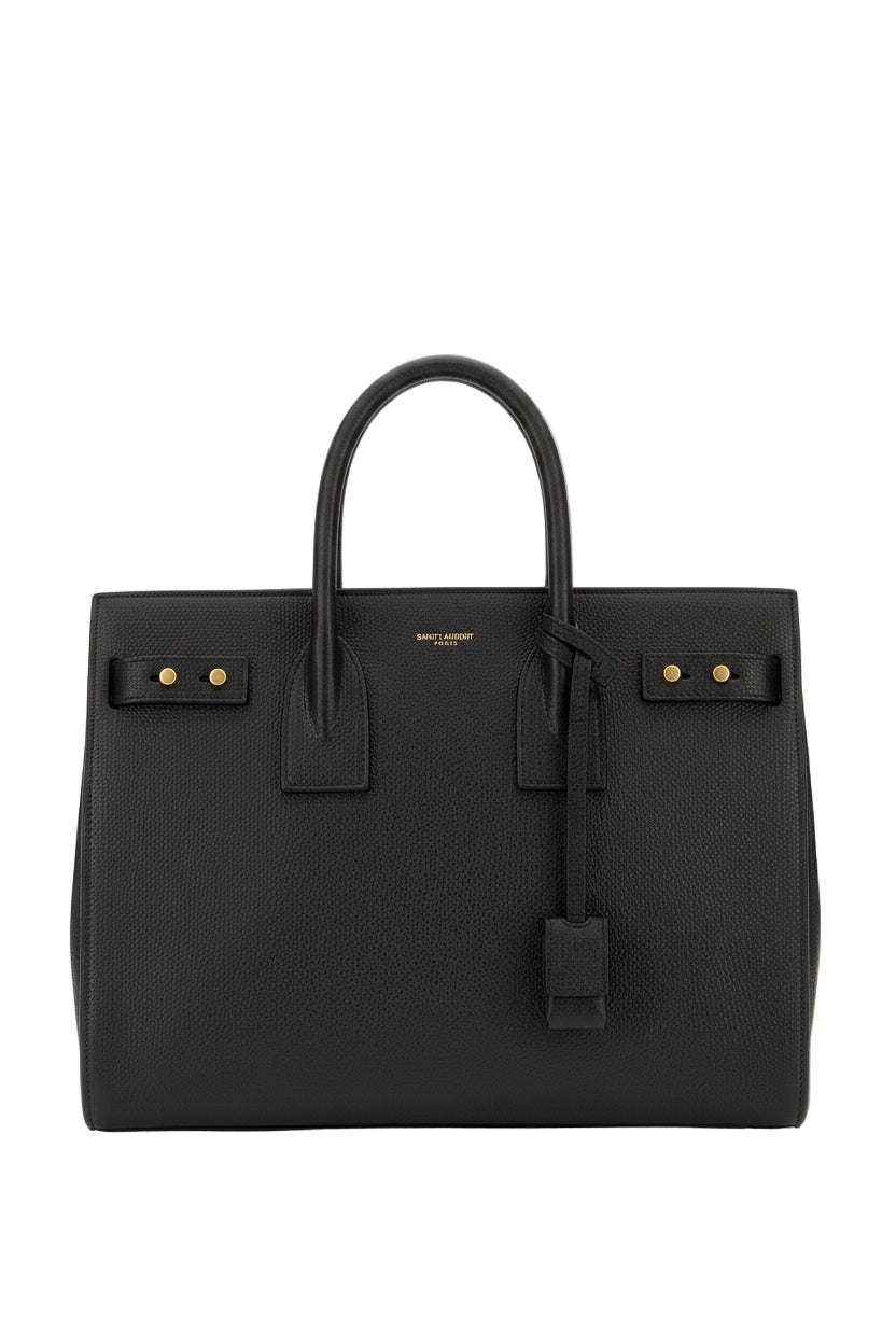 Black handbag with gold hardware on a white background