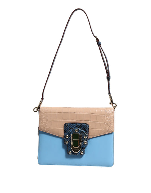 Two-tone beige and blue handbag with a decorative clasp on a white background