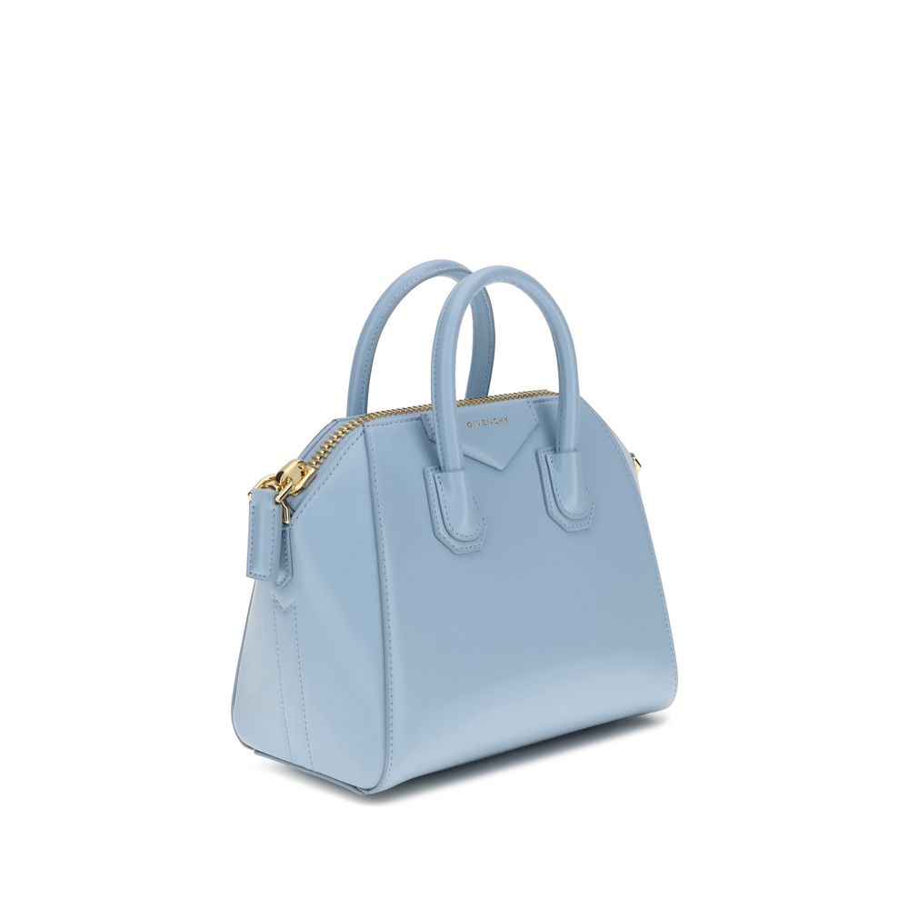 Light blue handbag with gold zipper on a white background