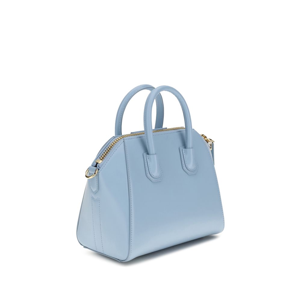 Light blue handbag with gold zipper on a white background