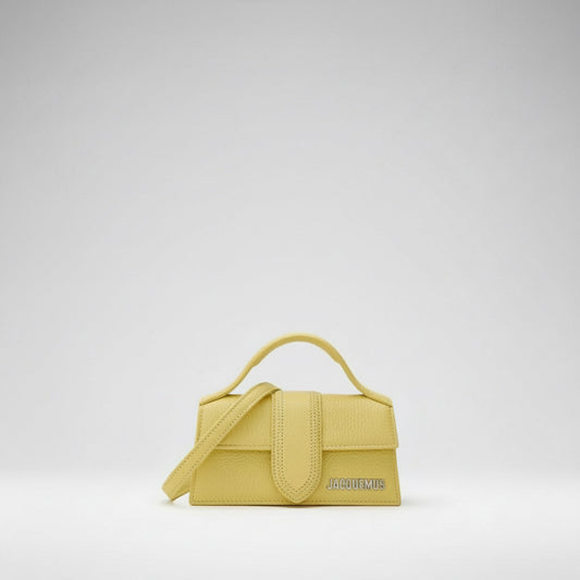 Yellow handbag with a visible brand logo on a white background